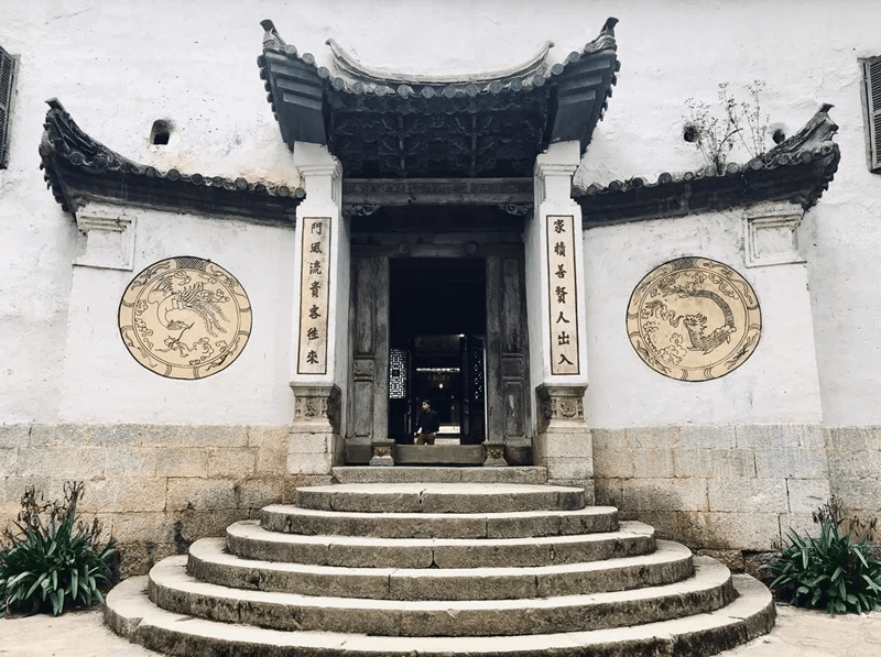 The ornate stone entrance of the Hmong King's Palace (Dinh Vua Meo) featuring Chinese-influenced architecture and traditional carvings in Sa Phin, Ha Giang.