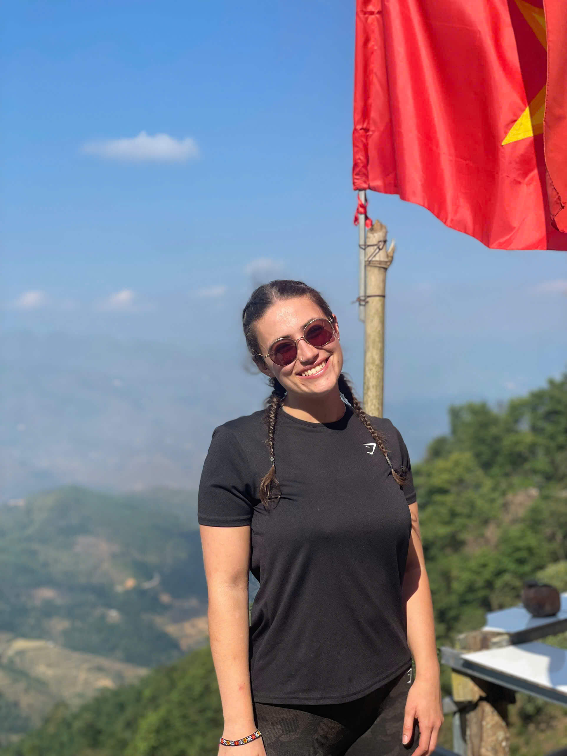 Solo female traveler admiring the spectacular winding mountain pass and deep valley on the Ha Giang Loop