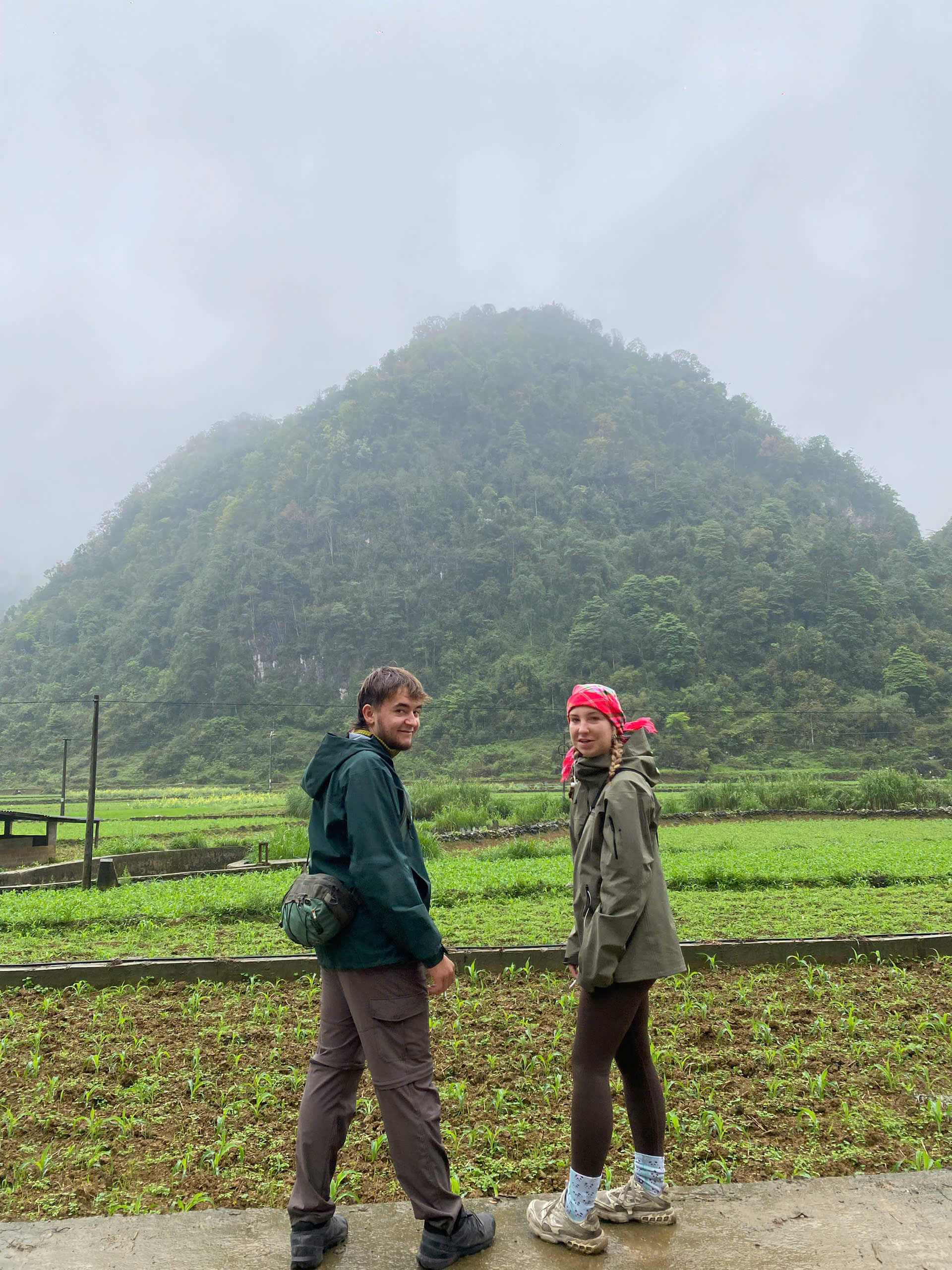 A happy couple exploring the untouched green valleys and misty mountains on the Cao Bang motorbike adventure.